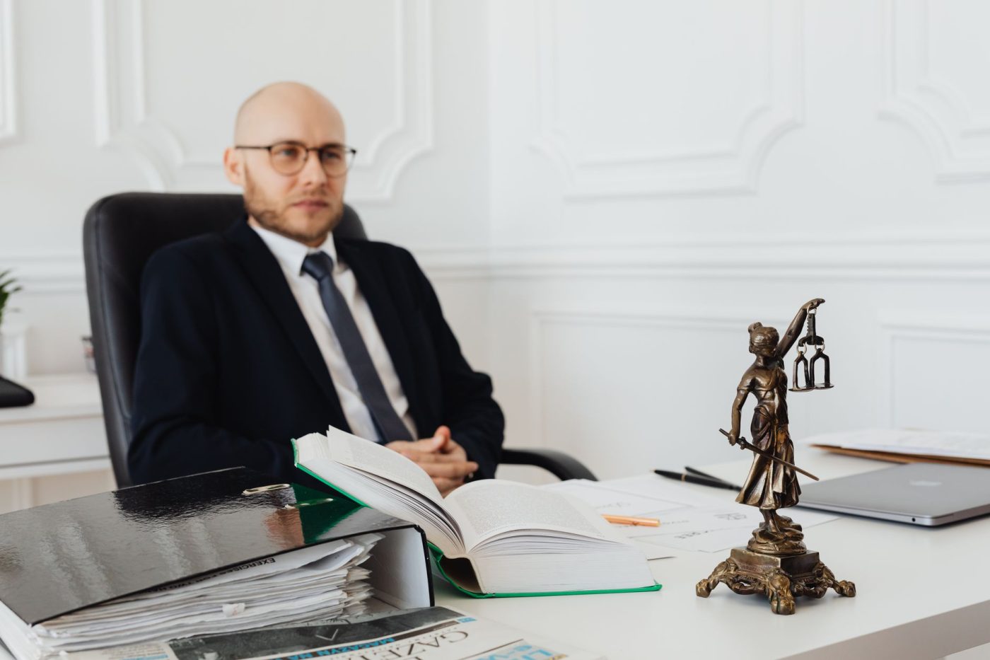 Юрист аналізує судовий позов проти OpenAI у світлому офісі з ноутбуком і паперами.